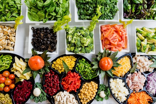 Refrigerator salad bar containing vegetables, beans, and protein for a healthy meal prep idea.